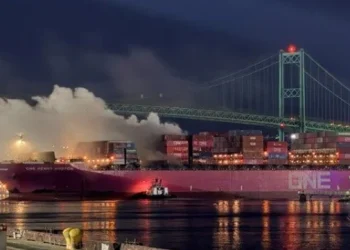 A container ship hit by a fire leaves Los Angeles for repairs in Asia