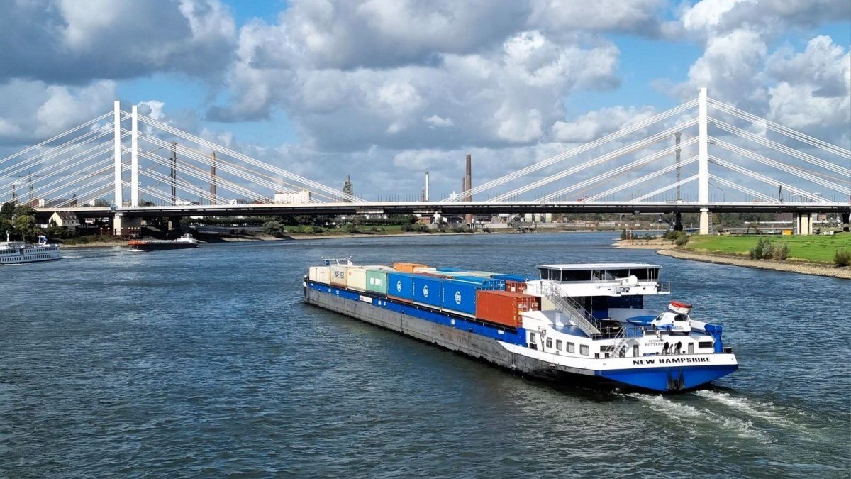 A container barge transits the Rhine River when water levels are normal.