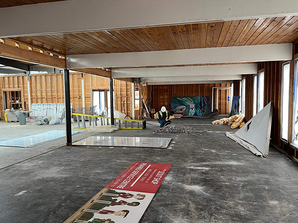 Intérieur en construction du National accessArts Centre, avec charpente en bois apparente et équipement de chantier